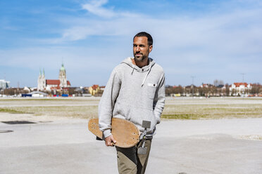 Mann trägt Longboard im Freien - DIGF04160