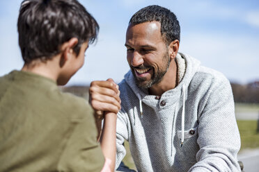 Vater und Sohn beim Armdrücken im Freien - DIGF04177