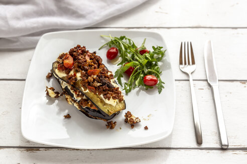 Auberginen-Lasagne auf Teller, Rucola und Tomate, vegetarisch - SARF03718