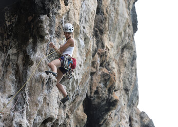 Thailand, Krabi, Chong Pli, Frau klettert in Felswand - ALRF01167