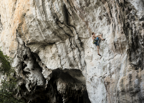 Thailand, Krabi, Railay Beach, barechested climber in rock wall stock photo