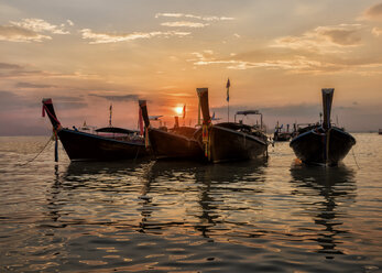 Thailand, Krabi, Railay Strand, Longtailboote schwimmen bei Sonnenuntergang auf dem Wasser - ALRF01174