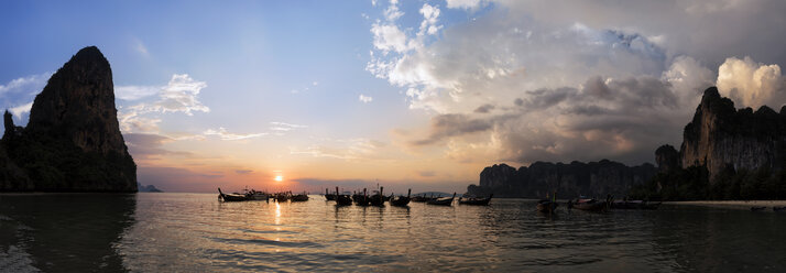 Thailand, Krabi, Railay Strand, Bucht mit Longtailbooten, die bei Sonnenuntergang auf dem Wasser treiben - ALRF01175