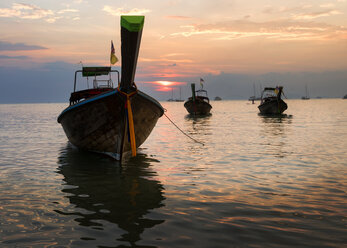 Thailand, Krabi, Railay beach, long-tail boats floating on water at sunset - ALRF01177