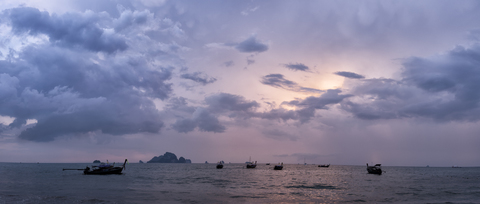 Thailand, Krabi, Tonsai Beach, Longtailboote schwimmen bei Sonnenuntergang auf dem Wasser, lizenzfreies Stockfoto