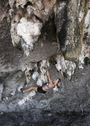 Thailand, Krabi, Insel Lao Liang, Frau beim Bouldern in der Felswand - ALRF01183