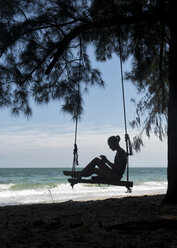 Thailand, Krabi, Insel Lao liang, Frau auf Baumschaukel am Strand - ALRF01187