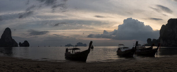 Thailand, Krabi, Railay Strand, Bucht mit Longtailbooten, die bei Sonnenuntergang auf dem Wasser treiben - ALRF01188