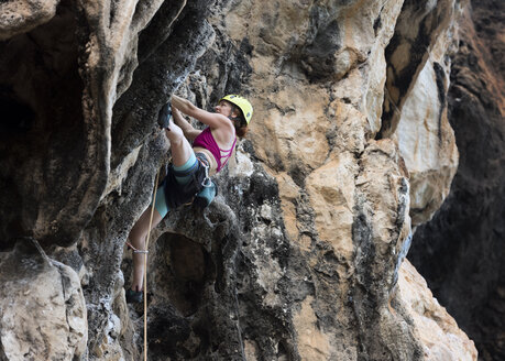 Thailand, Krabi, Thaiwand, Frau klettert in Felswand - ALRF01190