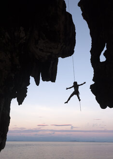 Thailand, Krabi, Insel Lao Liang, Kletterer beim Abseilen von einer Felswand über dem Meer - ALRF01195