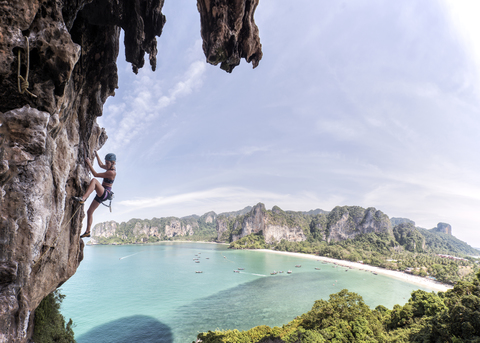 Thailand, Krabi, Thaiwand wall, woman climbing in rock wall above the sea stock photo