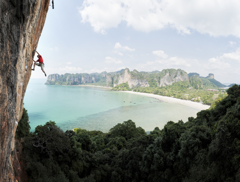 Thailand, Krabi, Thaiwand wall, man climbing in rock wall above the sea stock photo