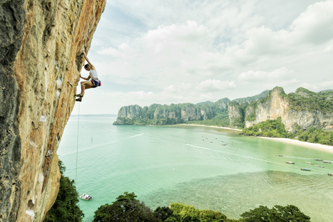 Thailand, Krabi, Thaiwand wall, woman climbing in rock wall above the sea stock photo