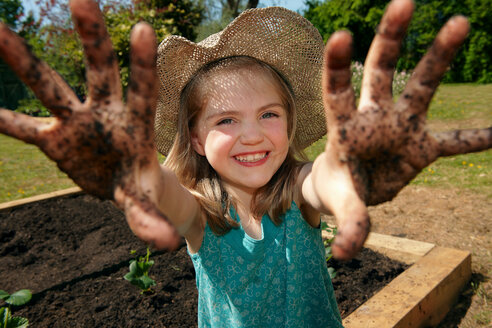 Junges Mädchen im Garten mit schlammigen Händen - CUF00955