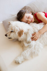 Girl relaxing with dog in bed - CUF01098