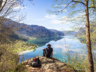 Italien, Lombardei, Frühling am Idrosee, Wanderer sitzt auf dem Aussichtspunkt - LAF02018