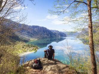 Italy, Lombardy, spring at Lake Idro, hiker sitting on observation point - LAF02018