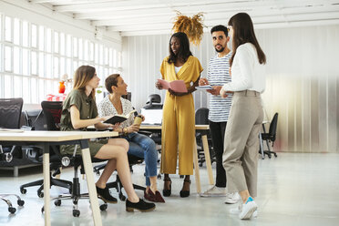 Kollegen mit Terminkalendern und Notizbüchern beim Brainstorming im Büro - EBSF02533