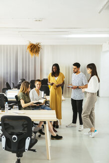 Kollegen mit Terminkalendern und Notizbüchern beim Brainstorming im Büro - EBSF02534