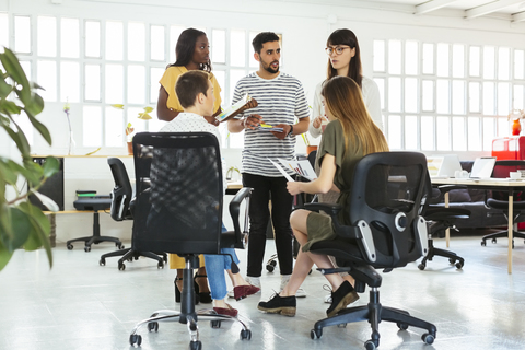 Colleagues discussing in office stock photo