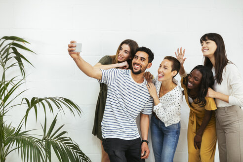 Verspielte Kollegen, die an einer Mauer stehen und ein Selfie machen - EBSF02565