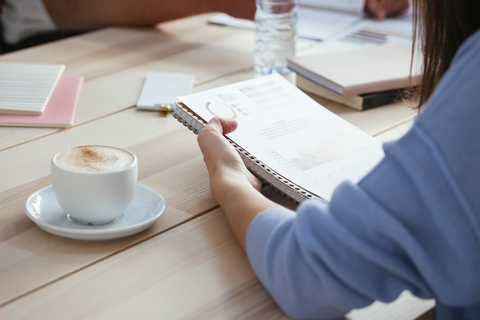 Frau arbeitet an Papier am Schreibtisch im Büro, lizenzfreies Stockfoto