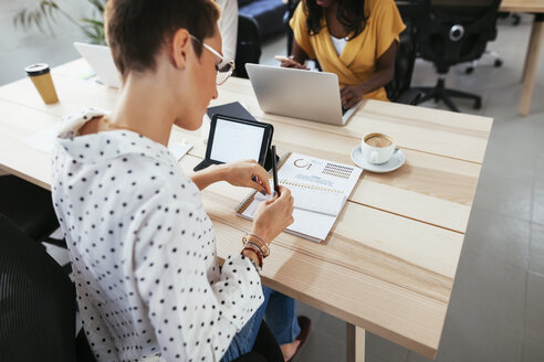 Frau arbeitet am Schreibtisch im Büro - EBSF02571