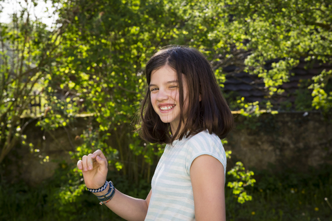 Porträt eines lachenden Mädchens im Garten, lizenzfreies Stockfoto