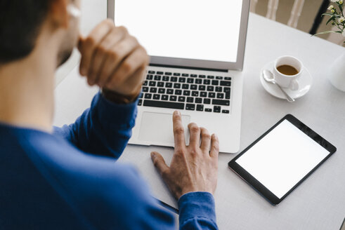 Close-up of man in a cafe using laptop - KNSF03863