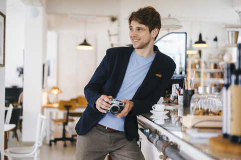 Lächelnder Mann in einem Cafe mit Kamera, lizenzfreies Stockfoto