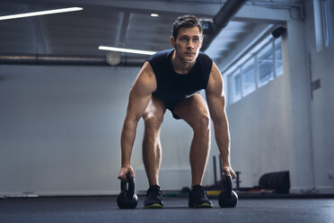 Mann macht Kettlebell-Übung im Fitnessstudio - BSZF00310