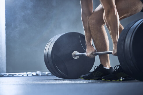 Close-up of man doing deadlift exercise at gym - BSZF00316