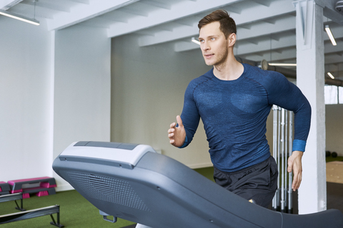 Mann läuft auf dem Laufband im Fitnessstudio, lizenzfreies Stockfoto