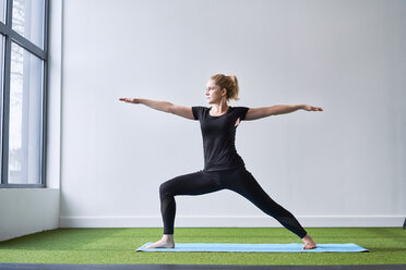 Woman doing yoga exercise in studio - BSZF00342