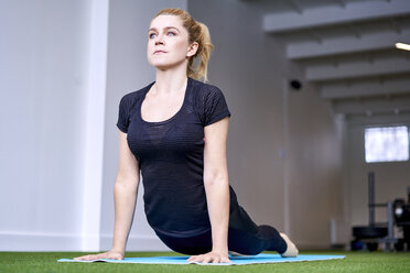 Woman doing yoga exercise in studio - BSZF00346