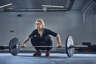 Frau bei einer Langhantelübung im Fitnessstudio während eines Krafttrainings - BSZF00362