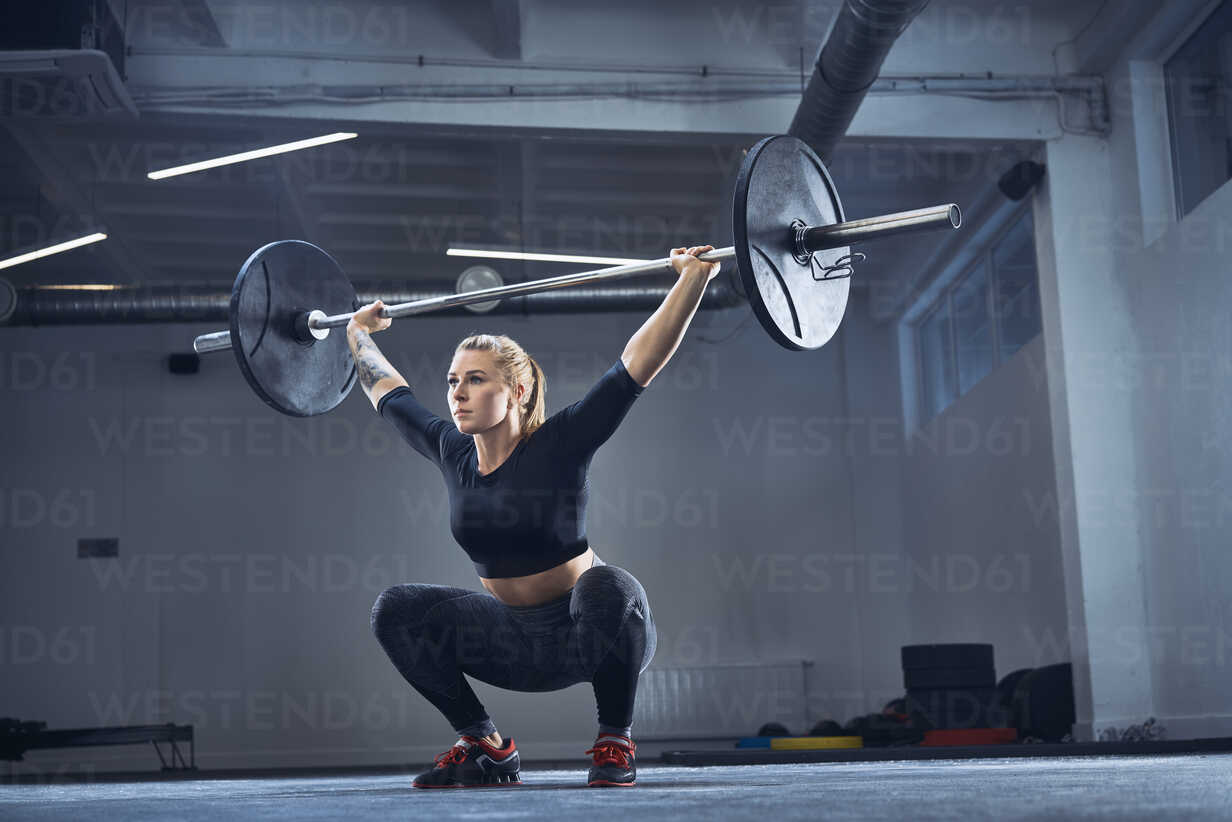 Woman doing overhead squat exercise at gym stock photo