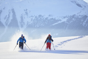 Austria, Tyrol, snowshoe hikers running through snow - CVF00418