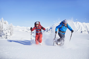 Austria, Tyrol, snowshoe hikers running through snow - CVF00426