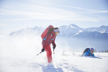 Austria, Tyrol, snowshoe hikers running through snow, man falling - CVF00427
