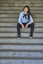 Porträt einer eleganten jungen Geschäftsfrau auf einer Treppe sitzend - BEF00028