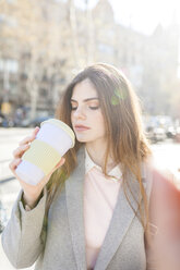 Spanien, Barcelona, Porträt einer jungen Frau, die einen Kaffee zum Mitnehmen trinkt - VABF01560