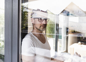 Portrait of pensive man standing behind glass door - UUF13504