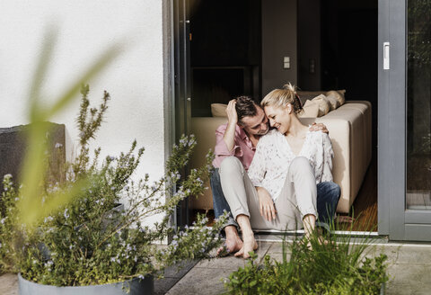 Happy mature couple relaxing together at open terrace door - UUF13544