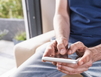 Man's hands text messaging, close-up - UUF13576