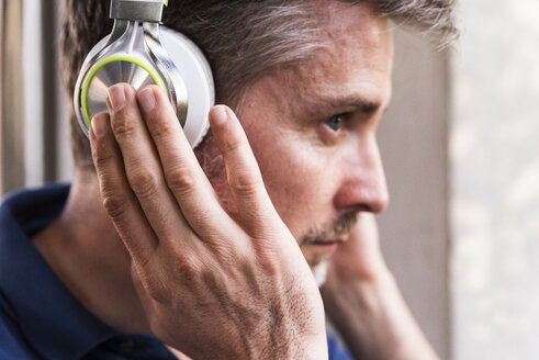 Mann hört Musik mit Kopfhörern, Nahaufnahme - UUF13577