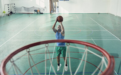 Man playing basketball, basketball hoop, indoor - ZEDF01362