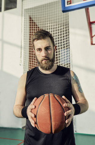Mann hält Basketball, innen, lizenzfreies Stockfoto