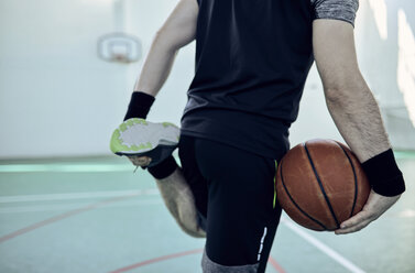 Mann mit Basketball, Bein ausstrecken, indoor - ZEDF01372