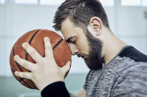 Mann mit Basketball, geschlossene Augen, innen, lizenzfreies Stockfoto